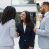 Female diverse business partners shaking hands with each other in hallway. Business man and women standing in office hall, talking and smiling. Successful partnership concept